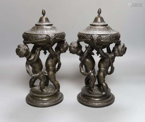 A pair of late 19th century patinated spelter lidded cherubi...