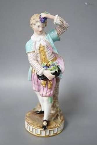 A 19th century Meissen figure of a boy holding grapes to his...