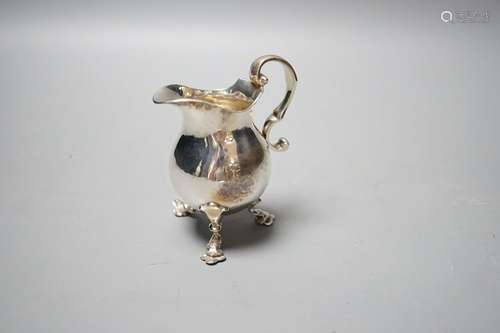 A George V silver cream jug, on tripod feet, William Comyns ...