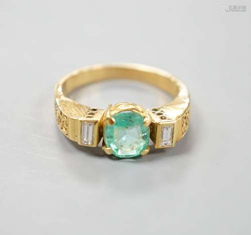 A modern yellow metal, round cut emerald and two stone bague...