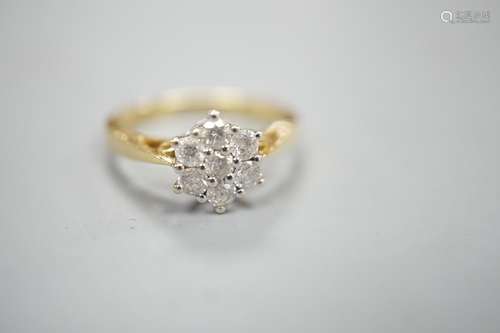 A modern 18ct gold and seven stone diamond set cluster ring,...