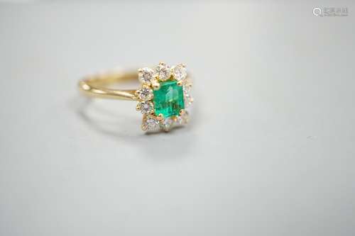 A 750 yellow metal, emerald and diamond set cluster ring, si...