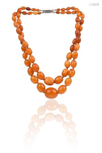 A two-row amber bead necklace, the oval beads graduate from ...