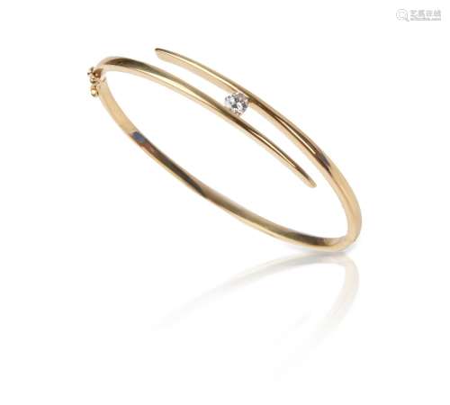 A diamond-set gold bangle, of crossover design, set with a b...