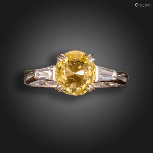 A yellow sapphire and diamond three-stone ring, the cushion-...