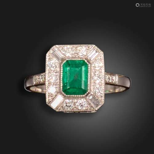 An emerald and diamond cluster ring, the emerald-cut emerald...