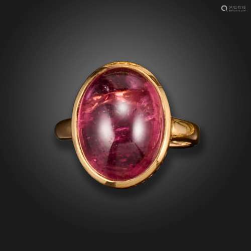 A tourmaline ring, the pink oval cabochon is rubover-set wit...