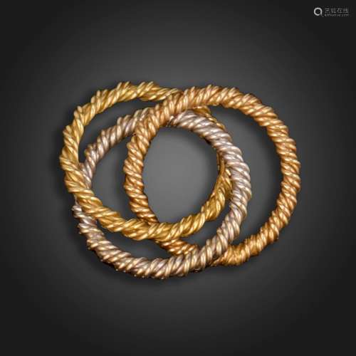 ‡ A gold trinity ring by Andrew Grima, the three entwined ro...
