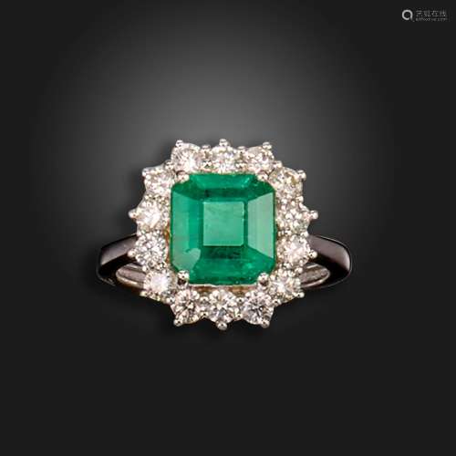 An emerald and diamond cluster ring, the emerald-cut emerald...