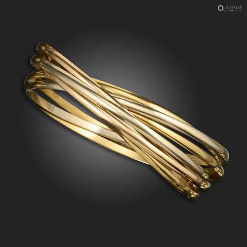 A gold multi-hoop bangle by Cartier, formed with seven inter...