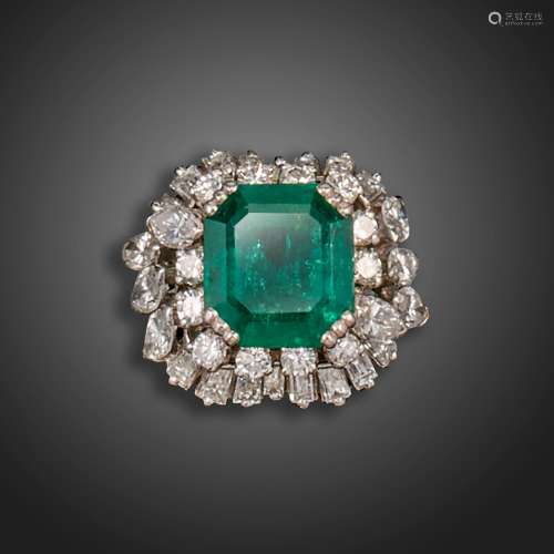 An emerald and diamond cluster ring, the emerald-cut emerald...