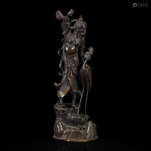 A patinated bronze figure of a Daoist immortal with crane 道...
