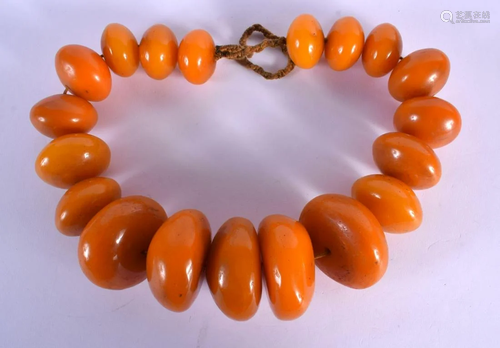 A LARGE MIDDLE EASTERN TRIBAL CARVED AMBER NECKLACE of monum...