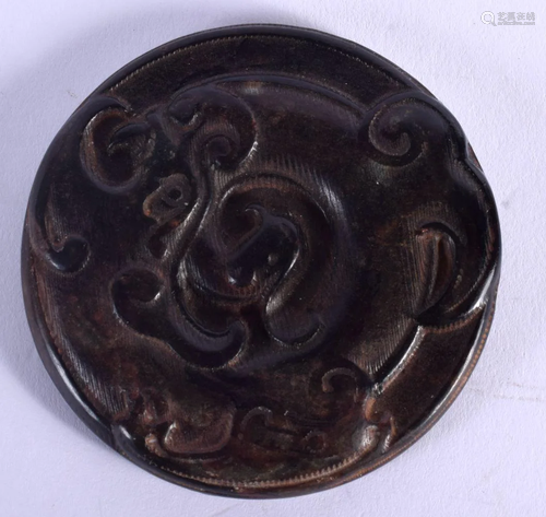 AN EARLY 20TH CENTURY CHINESE CARVED BLACK JADE DRAGON ROUND...