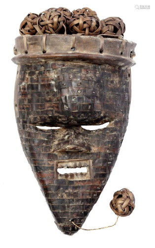 Wooden ceremonial mask covered with metal strips