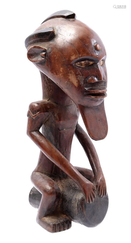 Wooden ceremonial statue of a man with drum