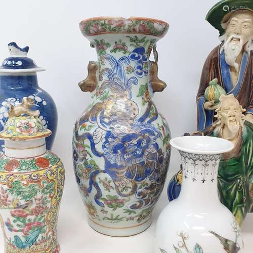 A Chinese famille rose clobbered vase, rim chipped and repai...