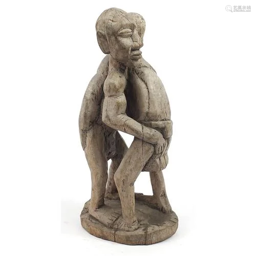 Tribal interest wood carving of two tribesmen wrestling, 40c...