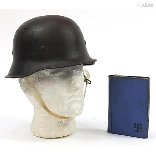 German military interest tin helmet with liner and a book