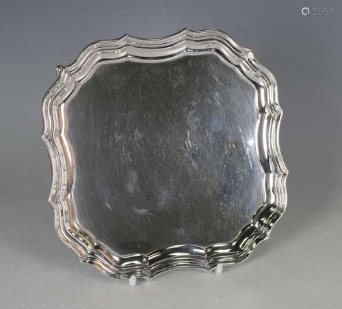 A George V silver shaped square card salver with raised scro...