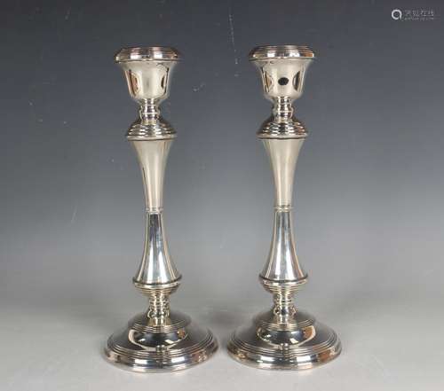 A pair of Elizabeth II silver candlesticks with reeded urn s...