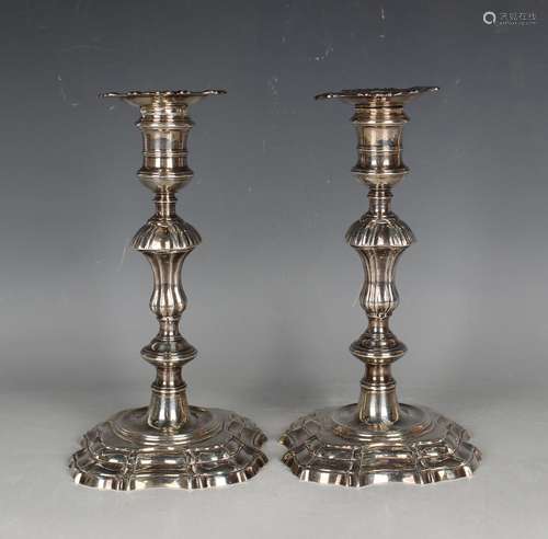 A pair of George II cast silver candlesticks, each with a de...