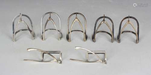 A set of five silver menu holders, each of arched form with ...