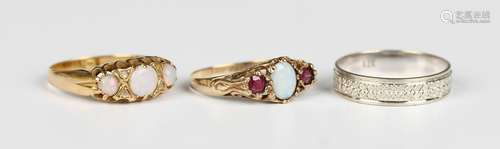 A gold ring, mounted with three circular opals and four diam...