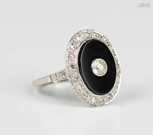 A black onyx and diamond ring of oval form, collet set with ...