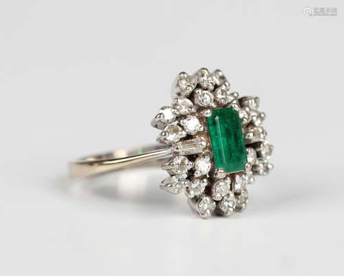 A white gold, emerald and diamond cluster ring, claw set wit...