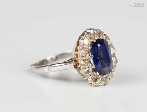 A sapphire and diamond cluster ring, claw set with the elong...