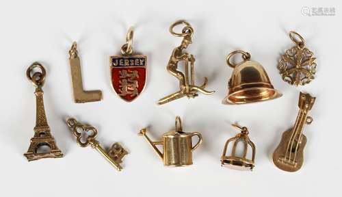 Three 9ct gold charms, comprising a helmet, a watering can a...