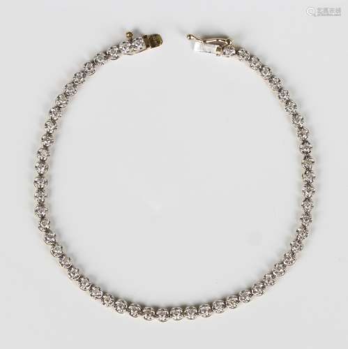 A 9ct gold and diamond bracelet, claw set with a row of circ...