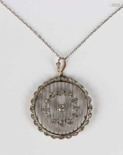 A gold backed, platinum fronted and diamond circular pendant...