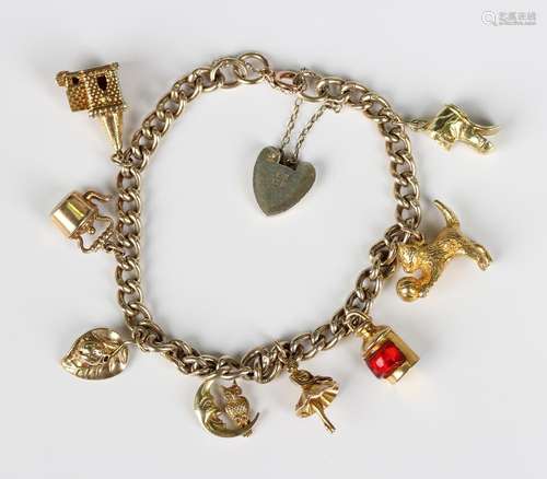 A silver gilt curblink charm bracelet on a silver gilt heart...