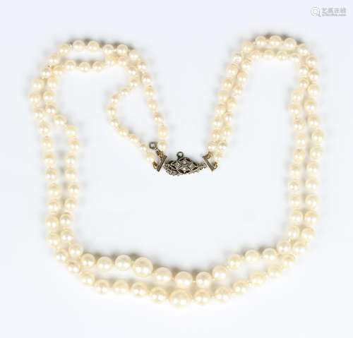 A two row necklace of graduated cultured pearls on a gold, p...