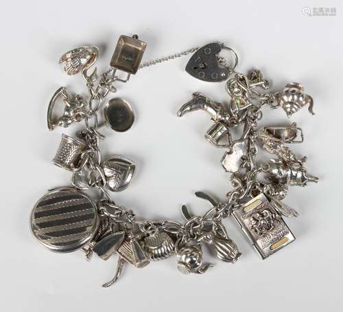 A silver curblink charm bracelet with a heart shaped padlock...