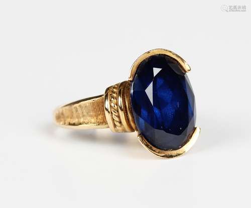 A gold ring, claw set with an oval cut synthetic blue spinel...