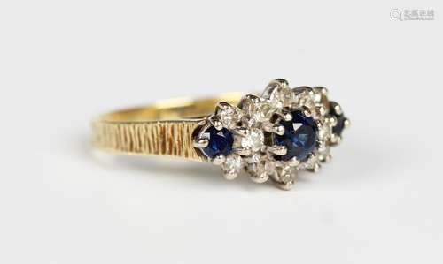 An 18ct gold, sapphire and diamond cluster ring, claw set wi...