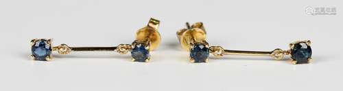 A pair of gold and sapphire two stone pendant earrings, each...