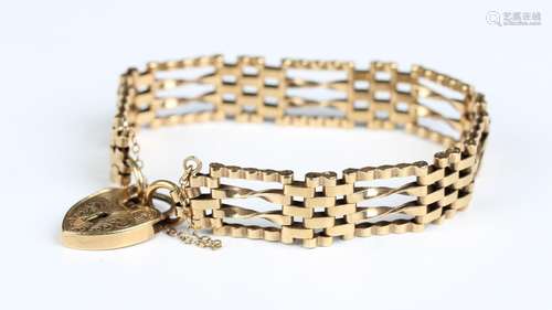 A 9ct gold twisted bar and oval link gate bracelet on a 9ct ...