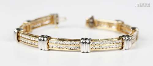 A two colour gold and diamond bracelet in a curved bar and r...