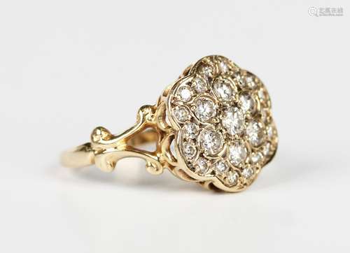 A gold and diamond cluster ring in a flowerhead shaped desig...