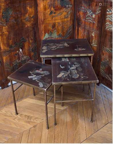Trois tables gigognes en bois laqué brun, argent et or, à dé...