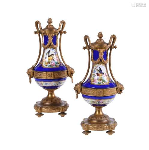 A PAIR OF SEVRES STYLE PORCELAIN AND GILT METAL MOUNTED URNS