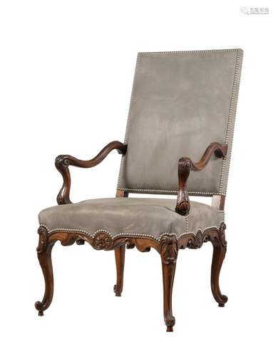 A FRENCH CARVED WALNUT AND UPHOLSTERED OPEN ARMCHAIR IN LOUI...