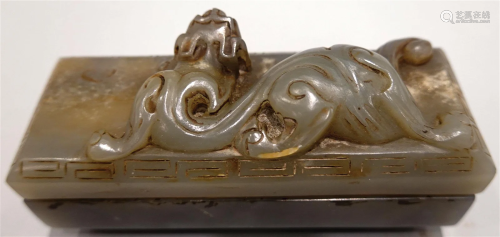 A greenish jade box with carving of dragon.