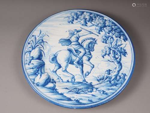 A faience charger with blue and white horse and rider decora...