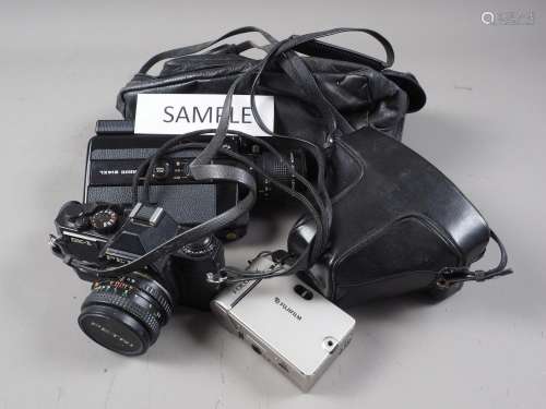 An Olympus OM10 camera, in case, a Petri GX-1 camera, a Cano...