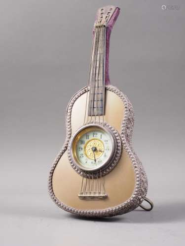 An easel clock, formed as an acoustic guitar with cream enam...